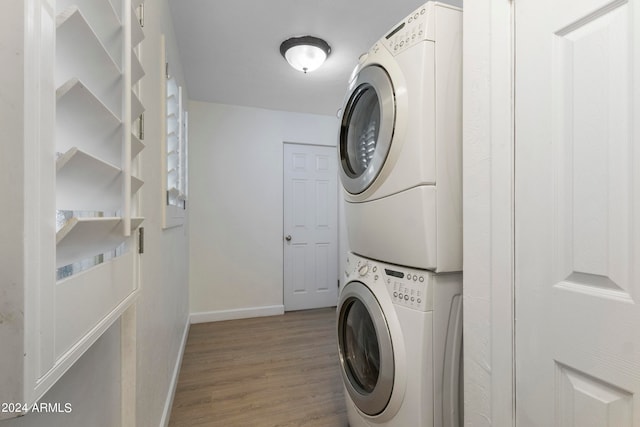 clothes washing area featuring stacked washer / dryer and hardwood / wood-style floors