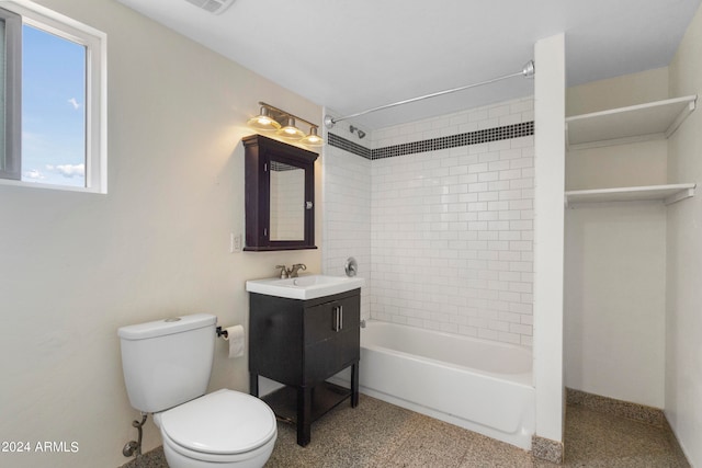 full bathroom with tiled shower / bath, vanity, and toilet