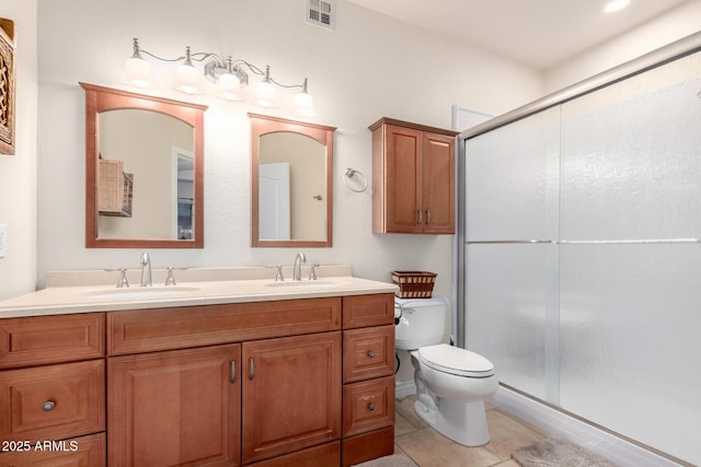 bathroom with walk in shower, vanity, tile patterned floors, and toilet