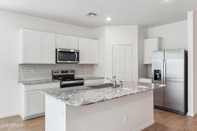 17806 W Vogel Ave, Waddell, AZ 85355 - kitchen featuring stainless steel appliances, wood tiled floors, a sink, tasteful backsplash, and recessed lighting