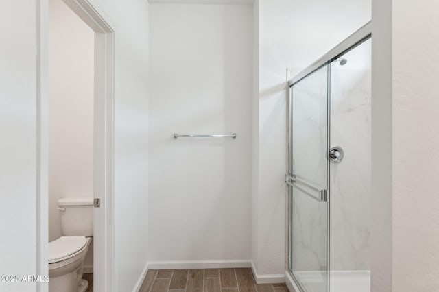 17806 W Vogel Ave, Waddell, AZ 85355 - bathroom with toilet, a marble finish shower, baseboards, and wood finished floors