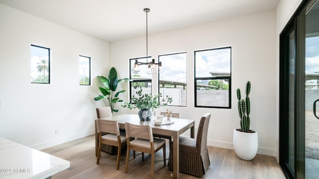 dining room with light hardwood / wood-style floors and an inviting chandelier