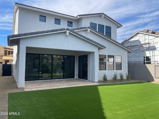 back of house featuring a patio area and a lawn