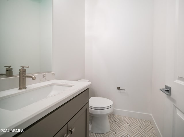 bathroom featuring tile patterned floors, vanity, and toilet