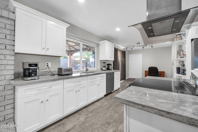 kitchen with light stone countertops, white cabinets, sink, rail lighting, and stainless steel dishwasher