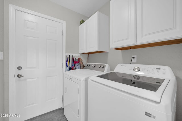 clothes washing area featuring cabinets and washing machine and clothes dryer