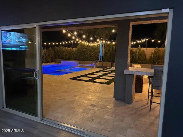 view of patio / terrace with a bar and a fenced in pool