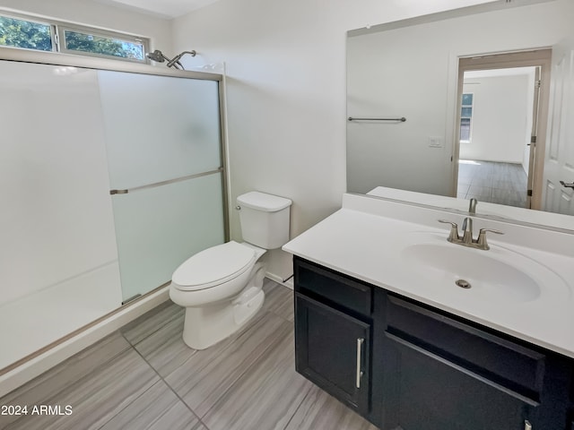 bathroom featuring walk in shower, tile flooring, vanity, and toilet