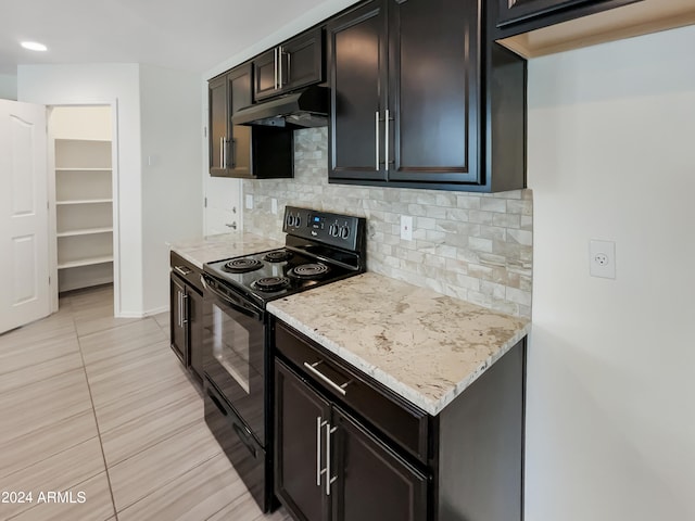 kitchen featuring black / electric stove, light stone counters, backsplash, and light tile floors