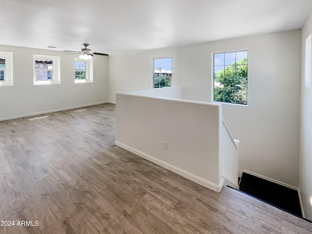 spare room with ceiling fan and light wood-type flooring