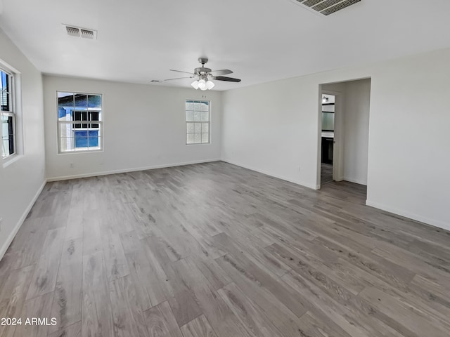 unfurnished room with plenty of natural light, ceiling fan, and hardwood / wood-style floors