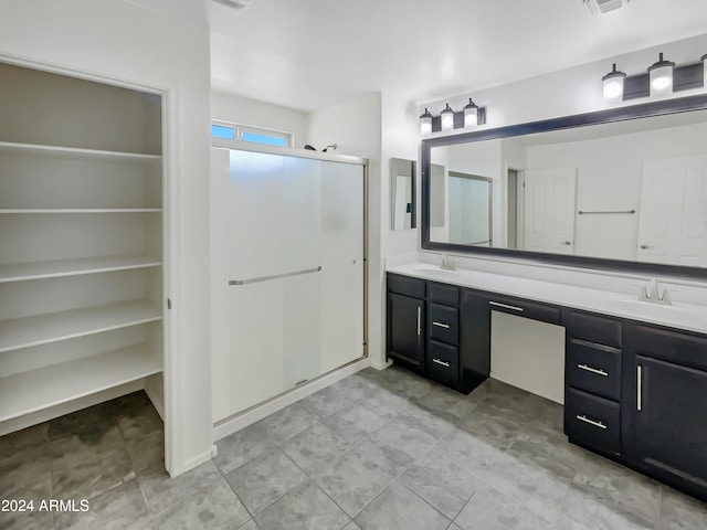 bathroom with a shower with shower door, tile flooring, and dual vanity