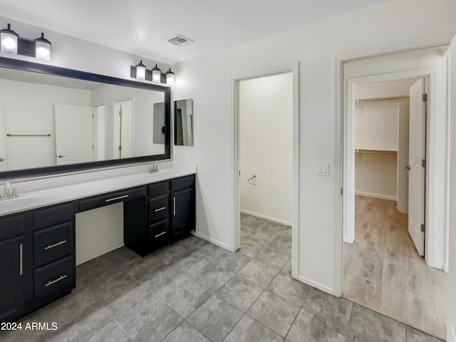 bathroom with hardwood / wood-style floors, oversized vanity, and dual sinks