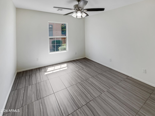 tiled spare room with ceiling fan