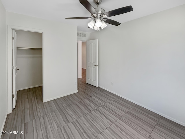 unfurnished bedroom featuring tile floors, ceiling fan, a closet, and a spacious closet