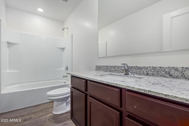 full bathroom with hardwood / wood-style flooring, vanity, shower / bath combination, and toilet