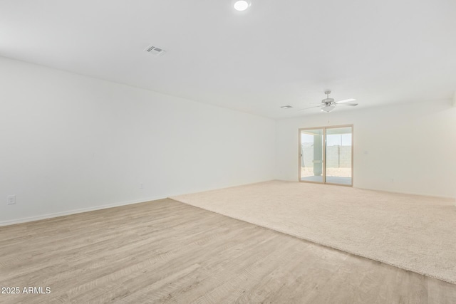 empty room with ceiling fan and light hardwood / wood-style floors