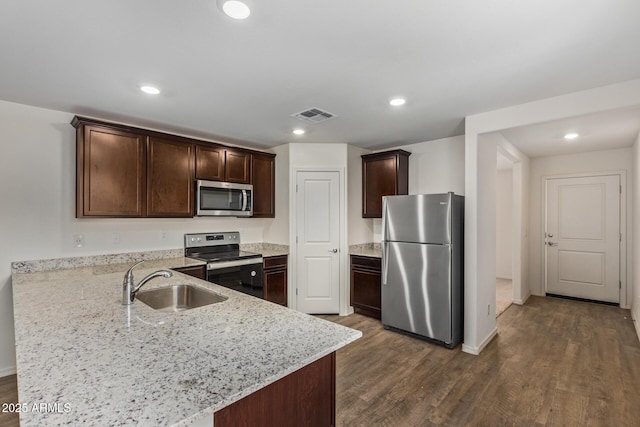 kitchen featuring dark hardwood / wood-style floors, sink, stainless steel appliances, light stone countertops, and dark brown cabinets