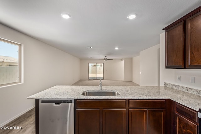 kitchen featuring sink, stainless steel dishwasher, light stone counters, and kitchen peninsula