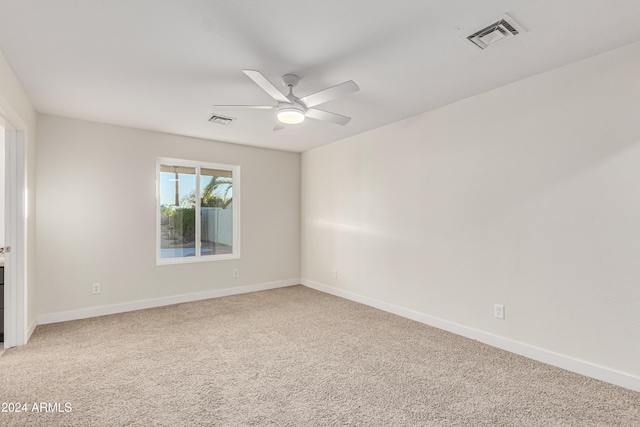 unfurnished room with ceiling fan and carpet