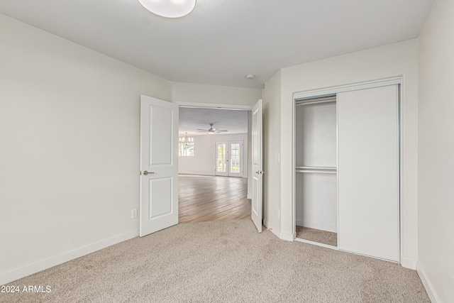 unfurnished bedroom featuring carpet flooring, a closet, and french doors