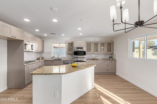 kitchen featuring appliances with stainless steel finishes, a center island, light hardwood / wood-style floors, and plenty of natural light