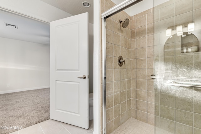 bathroom with tile patterned flooring, toilet, and an enclosed shower