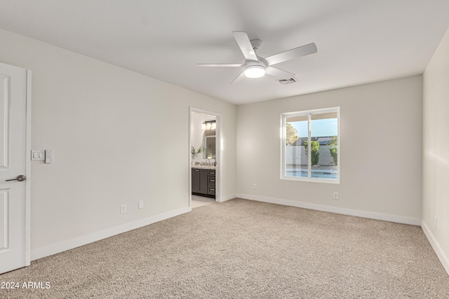 spare room with ceiling fan and light carpet