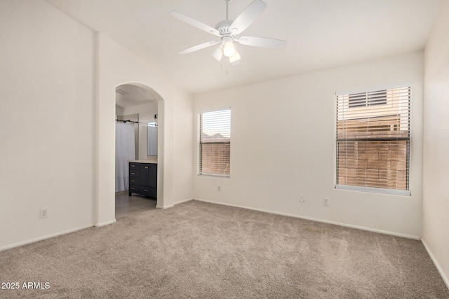 11531 E Persimmon Ave, Mesa, AZ 85212 - spare room with light colored carpet, arched walkways, ceiling fan, baseboards, and vaulted ceiling