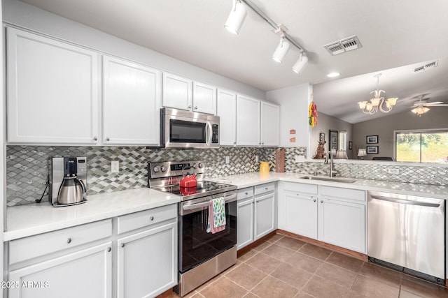 kitchen featuring tasteful backsplash, appliances with stainless steel finishes, sink, and white cabinets