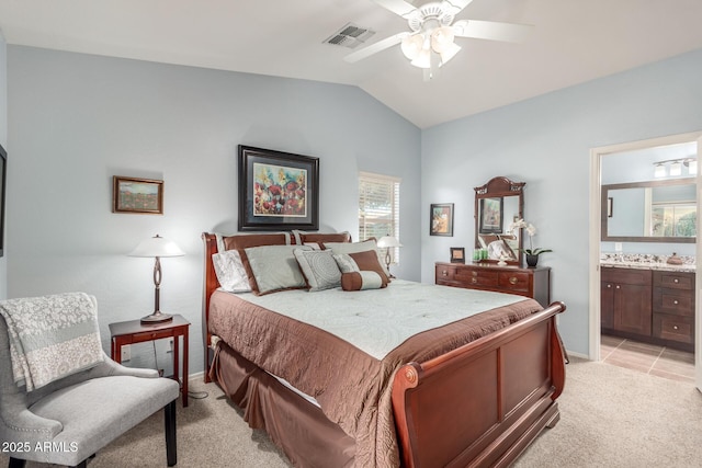 carpeted bedroom featuring vaulted ceiling, ceiling fan, and ensuite bathroom