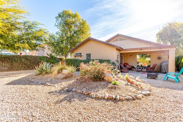 back of property with a patio area and an outdoor fire pit