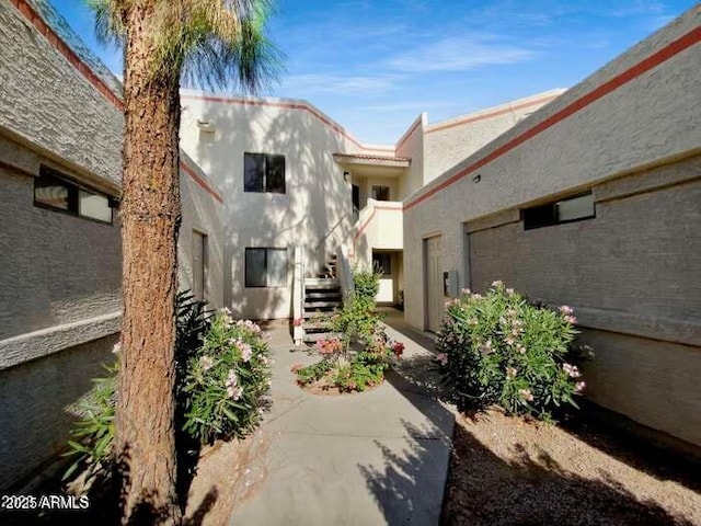 view of home's community with a patio and stairs