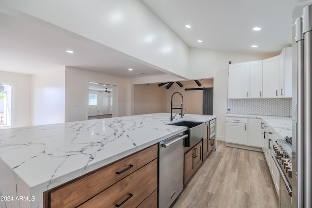 kitchen featuring light stone counters, sink, light hardwood / wood-style flooring, white cabinetry, and dishwasher