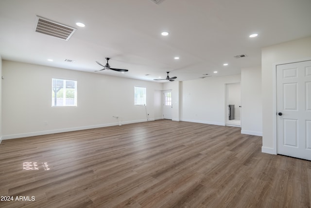 unfurnished room featuring hardwood / wood-style flooring, ceiling fan, and a wealth of natural light