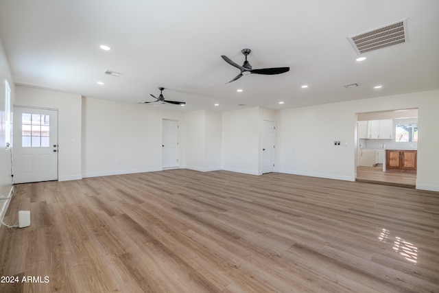 unfurnished living room with ceiling fan and light wood-type flooring