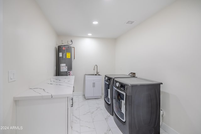 washroom with water heater, sink, washer and clothes dryer, and cabinets