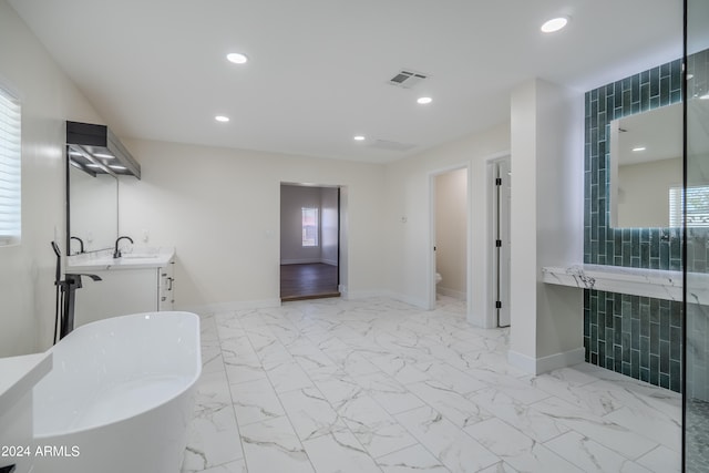 bathroom with vanity, toilet, and a bath