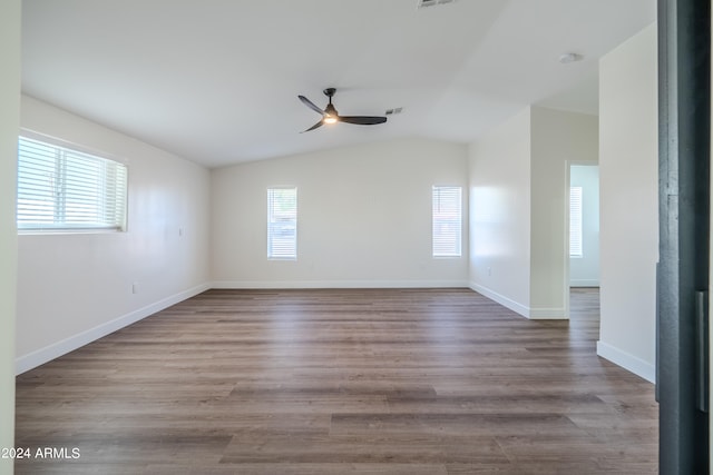 empty room featuring light hardwood / wood-style flooring, a wealth of natural light, vaulted ceiling, and ceiling fan