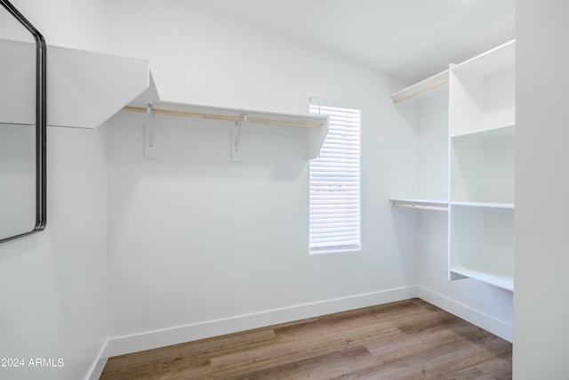 walk in closet with light hardwood / wood-style floors