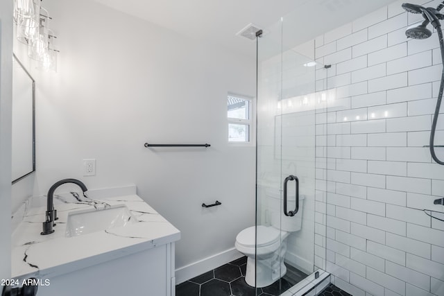 bathroom featuring tile patterned flooring, a shower with door, vanity, and toilet