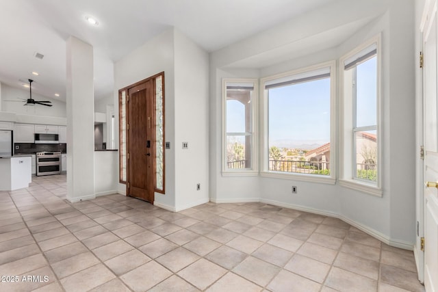 spare room featuring lofted ceiling, light tile patterned floors, and ceiling fan