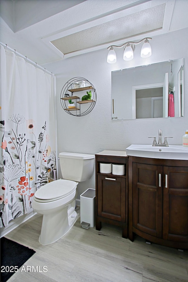 full bathroom with a shower with shower curtain, toilet, wood finished floors, and vanity