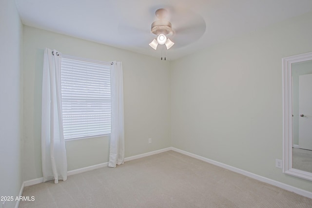 carpeted empty room with baseboards and ceiling fan