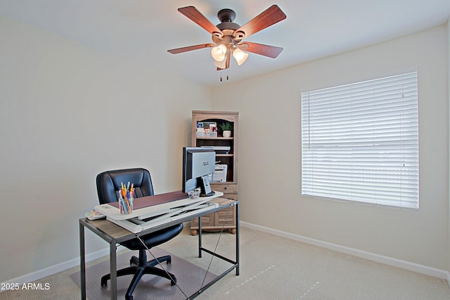 office space with light colored carpet, baseboards, and a ceiling fan