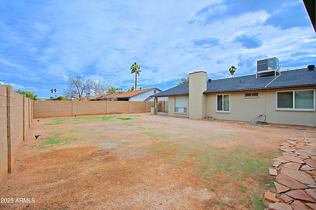 view of yard with central AC unit and a fenced backyard