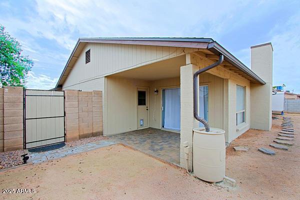 back of house featuring a patio, a chimney, and fence