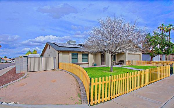 single story home featuring a fenced front yard, a front yard, and a gate