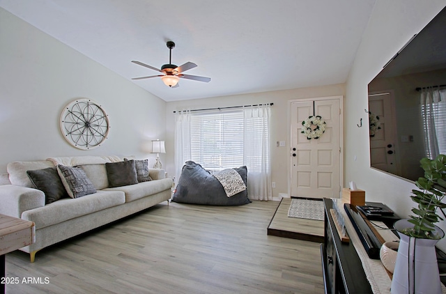 living area with light wood-style flooring, lofted ceiling, and a ceiling fan