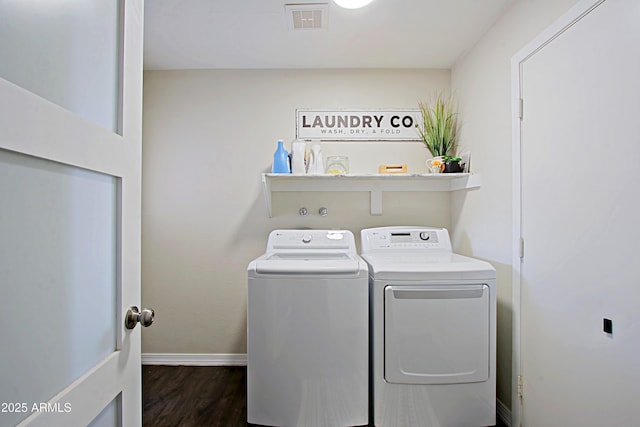 clothes washing area with washing machine and clothes dryer, visible vents, baseboards, laundry area, and dark wood-style floors